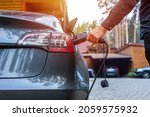 Electric car charging with station, EV fuel advance and modern eco system, Save the earth conception. man connecting a charging cable to a car from an electric car charging station.
