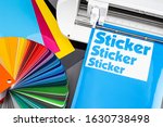 production making sticker with plotter cutting machine on CMYK cyan blue colored vinyl fim with color fan. guide. Advertising Industry diy design concept background.