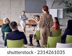 Small photo of A group of young business professionals in a modern office attentively listens to colleague presentation, showcasing a dynamic and collaborative atmosphere as they exchange ideas and strive for