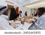 Small photo of In the sacred month of Ramadan, a Muslim family joyously comes together around a table, eagerly awaiting the communal iftar, engaging in the preparation of a shared meal, and uniting in anticipation