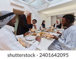 Small photo of In the sacred month of Ramadan, a Muslim family joyously comes together around a table, eagerly awaiting the communal iftar, engaging in the preparation of a shared meal, and uniting in anticipation