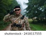 Small photo of A dedicated soldier salutes his elite unit, showcasing camaraderie and readiness for the most perilous military operations