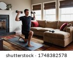 Fit man exercising at home with ...