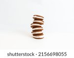 Small photo of wobbly stack of gingerbread whoopie pies on white seamless