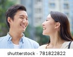 portrait of young Chinese couple standing & smiling at each other outdoor in garden
