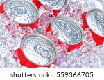 Closeup of a group of soda cans in ice with condensation.