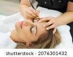 Small photo of Permanent Makeup For Eyebrows. Microblading brow. Beautician Doing Eyebrow Tattooing For Female Face. Beautiful young girl in a beauty salon