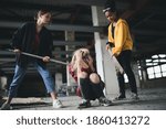 Small photo of Teenage girl attacked by thugs in abandoned building, gang violence and bullying concept.