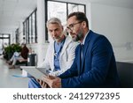 Small photo of Pharmaceutical sales representative talking with doctor in medical building. Ambitious male sales representative presenting new medication.