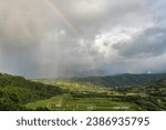 View of the beautiful Hanalei Valley with a rainbow and rain clouds from the Hanalei Valley Lookout in Princeville, Kauai, Hawaii, United States. 
