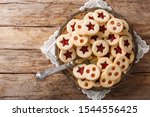 Christmas shortbread Linzer cookies with jam filling close-up on a plate on the table. Horizontal top view from above