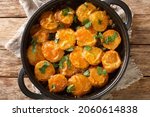 Small photo of Fried Spanish potatoes in a spicy sauce Patatas a la importancia closeup in a frying pan on the table. horizontal top view from above