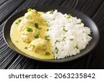 Small photo of Traditional recipe for Danish Meatballs in Curry Boller i Karry with rice garnish close up in the plate on the table. horizontal