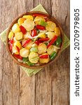 Small photo of Traditional Spanish stew being cooked patatas a lo pobre witr potatoes, onion and bell pepper close up in the plate on the table. Vertical top view from above