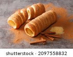 Trdelnik Czech is a kind of spit cake it is made from rolled dough that is wrapped around a stick, then grilled and topped with sugar and cinnamon close up on the table. Horizontal