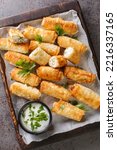 Small photo of sigara boregi is a famous Turkish deep-fried pastry crispy rolls of thin dough are stuffed with a creamy mixture of cheese and parsley closeup. Vertical top view from above