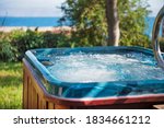 Jacuzzi close up focus in the water with a blurry garden and sea view background 