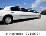 White stretch limousine with partly cloudy blue sky