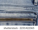Metal zipper on light blue jeans pocket.
