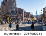 Crowds of people walking across a busy intersection on 7th Avenue in the West Village neighborhood of New York City NYC