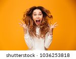 Image of excited screaming young woman standing isolated over yellow background. Looking camera.