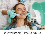 Small photo of European young woman smiling while looking at mirror in dental clinic