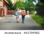 Small photo of Boy and girlie go to school having joined hands. Warm September day. Good mood. Behind backs at children satchels. The girlie laughs. Back to school. Little first grader.