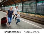 Small photo of Family of three people hotfoot on platform of railway train station. They are late for a train. Mum holds the son by the hand. Adults roll greater suitcases.