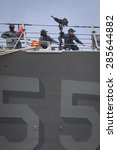 Small photo of STATEN ISLAND, NY - MAY 20 2015: Low angle view of linesmen work from the bow of the USS Stout (DDG 55) guided-missile destroyer while mooring for Fleet Week NY 2015 at Sullivans Pier