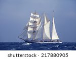 Barquentine with white sails in the calm sea