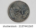 Small photo of A quarter dollar (25 cents) coin with the image of Oklahoma (the Sooner State), USA.