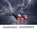 Small photo of USA paper boat made as the flag of the US almost capsizes in high waves. Bolt of lightning in stormy dark sea weather during a thunder-storm with dramatic cloudscape. USA finacial crisis concept.