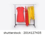 Fashionable yellow, red clothes with suit winter jacket with red, yellow dress ,sundress on hanger

