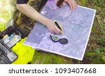 Small photo of Close up female hands marking waypoints on the map with compass.