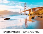 Classic panoramic view of famous Golden Gate Bridge seen from scenic Baker Beach in beautiful golden evening light on a sunny day with blue sky and clouds in summer, San Francisco, California, USA