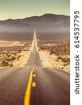 Small photo of Classic vertical view of an endless straight road running through the barren scenery of famous Death Valley with extreme heat haze on a beautiful sunny day with blue sky in summer, California, USA