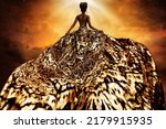 Fashion Model in Golden flying Dress looking away at Light. Afro Style Woman in Gold Long Gown fluttering on Wind rear view. Exotic Dancer with Silk Fabric over Art Fantasy Background