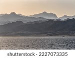Mountains silhouettes and sea at sunset or sunrise