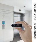 Small photo of pm2.5 sensor. measuring air quality in an elevator hallway. bad indoor air quality lots of harmful particulate matter air pollution content. harmful living environment.