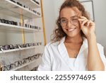 Client Woman At Eyeglasses Store Portrait. Cheerful Female Model In Fashion Eye Glasses With Natural Face Makeup Smiling at Shop. Good Vision Concept