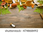 Small photo of Fall harvest forest mushrooms on a rustic wooden background, natural autumn style decorations. Background space for text. Natural plenteous border background vintage mock up.