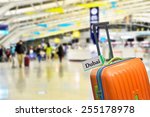 Dubai. Orange suitcase with label at airport.