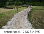 Small photo of Scenic view of the bamboo bridge to the village. Passing through the middle of rice fields is a beautiful natural place. Located in Phrae Province, Thailand.