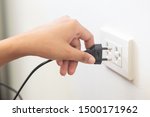 Small photo of using electricity wall outlet with wet hand; electrocute danger concept