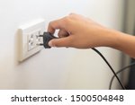 Small photo of using electricity wall outlet with wet hand; electrocute danger concept