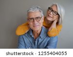  Portrait of relaxed fun senior couple wearing glasses on background                              