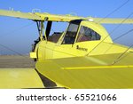 Yellow crop duster biplane with spray nozzles mounted on wing trailing edge