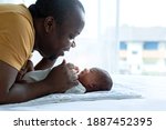 Small photo of African dad playing tease with newborn baby, newborn baby 15 days old looking his father, African family and newborn concept, father's day