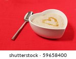 porridge in a heart shape bowl on red canvas background with honey