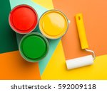 three cans  yellow green and red and paint roll on colourful geometrical background
